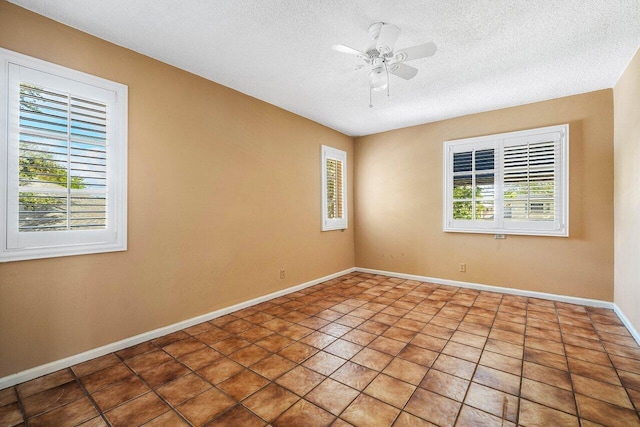 empty room featuring baseboards, ceiling fan, and a textured ceiling