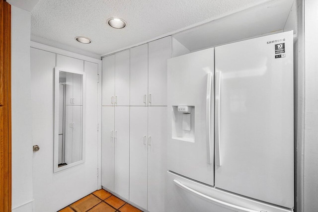 bathroom with a textured ceiling and tile patterned floors