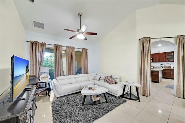 living area with visible vents, light tile patterned floors, ceiling fan, and vaulted ceiling