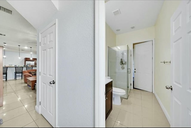 corridor with light tile patterned flooring, visible vents, and baseboards
