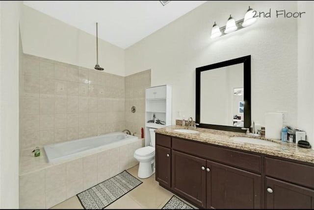 bathroom with toilet, double vanity, a sink, and tiled shower / bath
