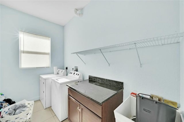 washroom featuring baseboards, light tile patterned floors, cabinet space, and washer and clothes dryer