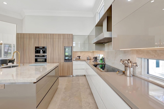 7090 Ayrshire Ln, Boca Raton, FL 33496 - kitchen featuring modern cabinets, a sink, black electric cooktop, wall chimney range hood, and ornamental molding