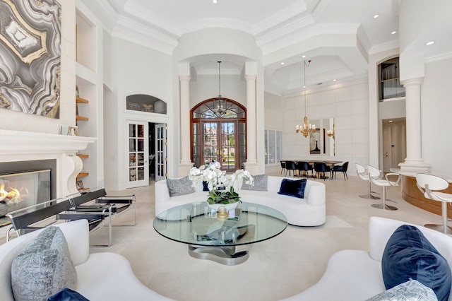 7090 Ayrshire Ln, Boca Raton, FL 33496 - living room with decorative columns, built in features, a chandelier, french doors, and a glass covered fireplace
