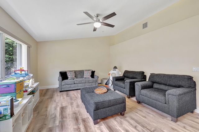 living area with a ceiling fan, visible vents, light wood-style flooring, vaulted ceiling, and baseboards