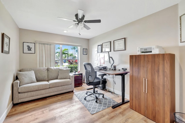 home office with baseboards, a ceiling fan, and light wood finished floors