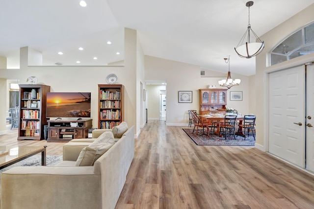 living area with baseboards, recessed lighting, an inviting chandelier, and light wood finished floors