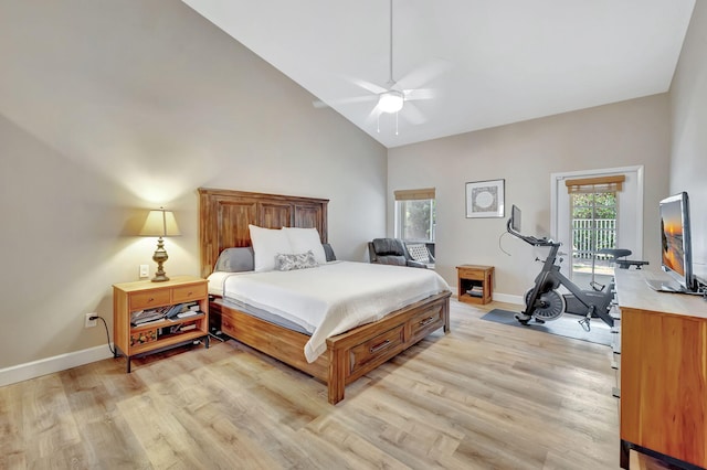 bedroom featuring light wood-style floors, high vaulted ceiling, and baseboards