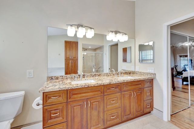 full bath featuring toilet, a shower stall, ensuite bathroom, and a sink