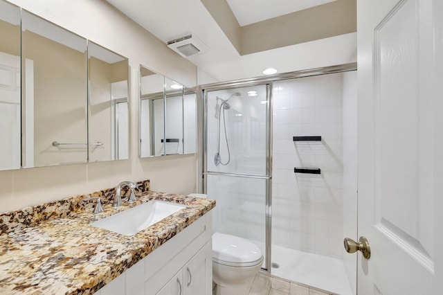 bathroom featuring vanity, toilet, and a stall shower