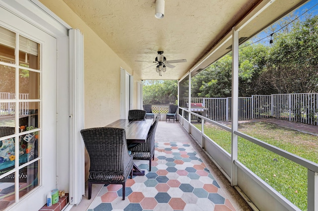 sunroom / solarium featuring ceiling fan