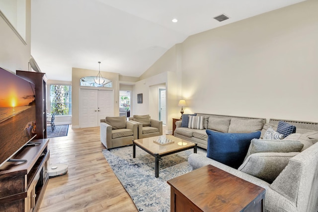 living area featuring recessed lighting, light wood-type flooring, visible vents, vaulted ceiling, and baseboards
