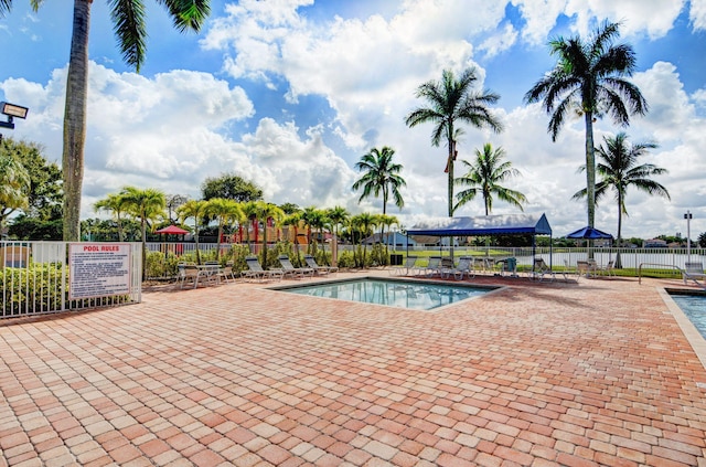 pool featuring fence and a patio area