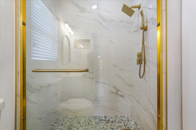 bathroom featuring a marble finish shower