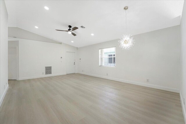 unfurnished room with ceiling fan with notable chandelier, lofted ceiling, light wood-type flooring, and visible vents