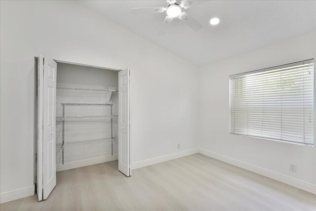 unfurnished bedroom featuring baseboards, a ceiling fan, wood finished floors, and a closet