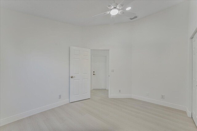 spare room with visible vents, a ceiling fan, light wood-style flooring, and baseboards