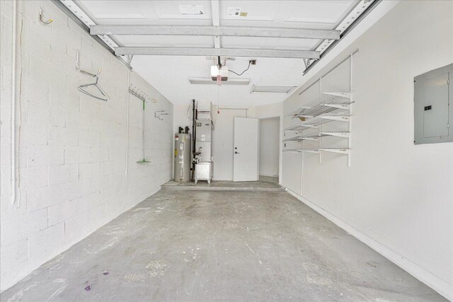 garage with concrete block wall, a garage door opener, water heater, and electric panel