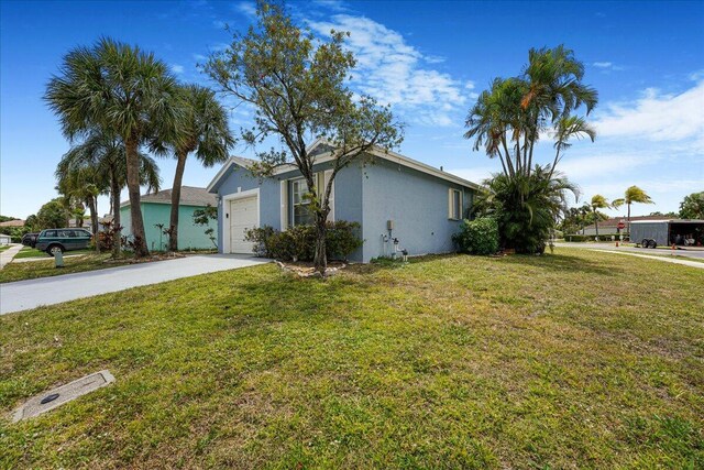 view of front facade with a garage, stucco siding, concrete driveway, and a front yard