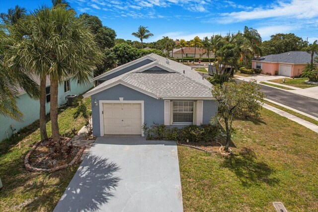 ranch-style home featuring an attached garage, a shingled roof, stucco siding, a front yard, and concrete driveway