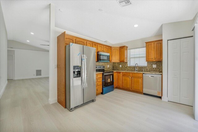 kitchen with decorative backsplash, stainless steel appliances, light wood finished floors, and visible vents