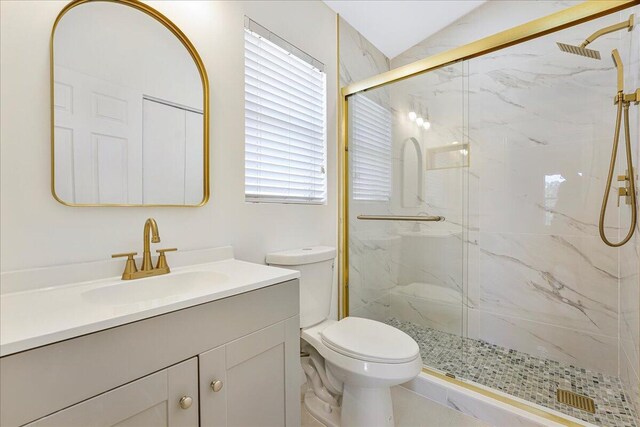 bathroom with vanity, toilet, and a marble finish shower