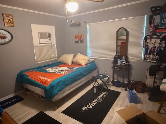 1126 S L St, Lake Worth Beach, FL 33460 - bedroom with ornamental molding, a ceiling fan, an AC wall unit, and wood finished floors