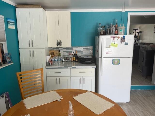 1126 S L St, Lake Worth Beach, FL 33460 - kitchen featuring washer / clothes dryer, light countertops, white cabinets, freestanding refrigerator, and light wood-style floors