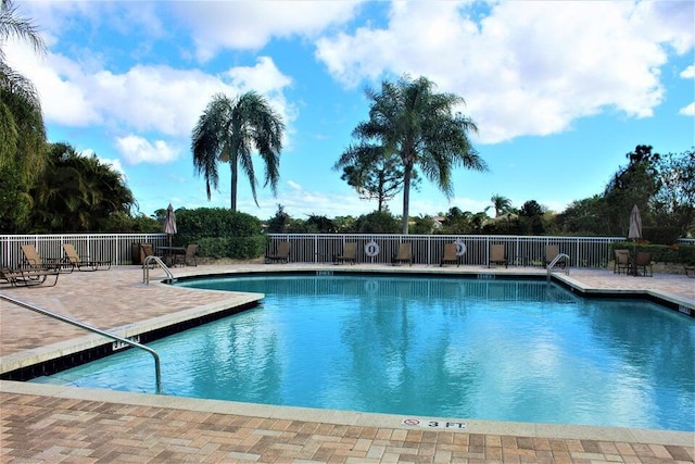 community pool with fence and a patio
