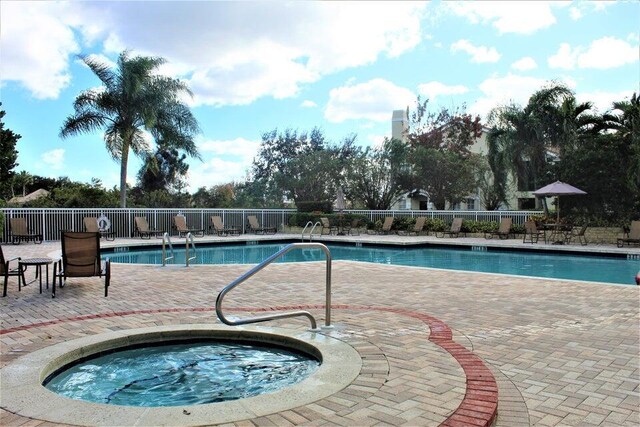 pool featuring fence, a community hot tub, and a patio