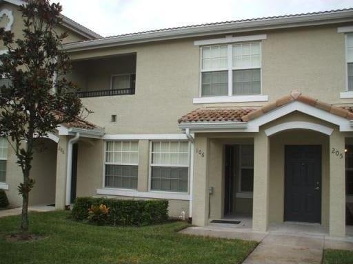 view of front of home featuring a front lawn, stucco siding, and a tiled roof