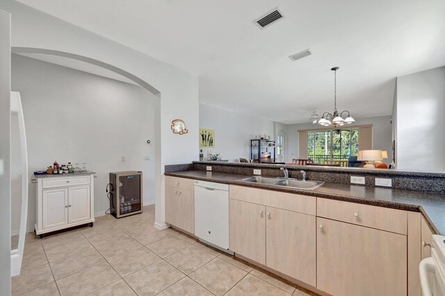 kitchen with white dishwasher, light tile patterned flooring, a sink, stove, and visible vents
