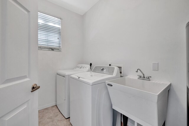 washroom featuring a sink, laundry area, light tile patterned flooring, and independent washer and dryer