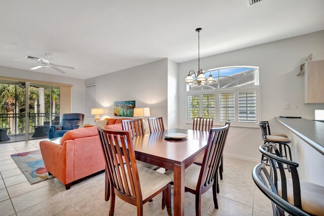 dining space featuring light tile patterned flooring and ceiling fan with notable chandelier