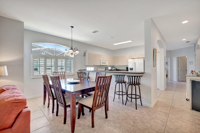 dining area with baseboards, recessed lighting, light tile patterned flooring, and an inviting chandelier