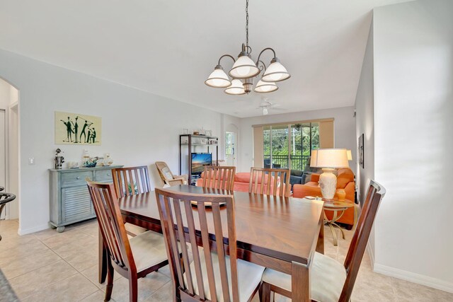 dining space with arched walkways, baseboards, a notable chandelier, and light tile patterned floors