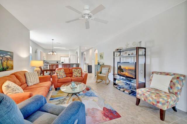 living area featuring ceiling fan with notable chandelier and light tile patterned flooring