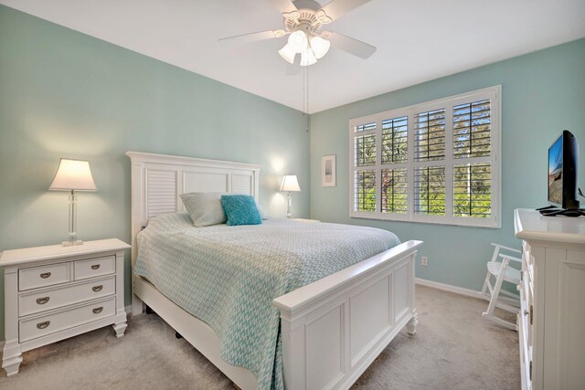 bedroom with baseboards, ceiling fan, and light carpet