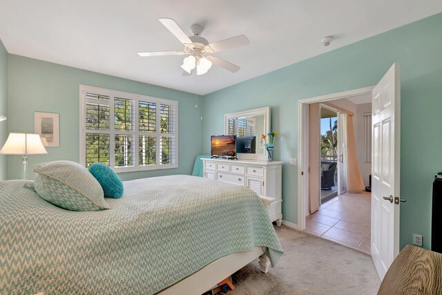 bedroom featuring light tile patterned floors, baseboards, a ceiling fan, and light colored carpet