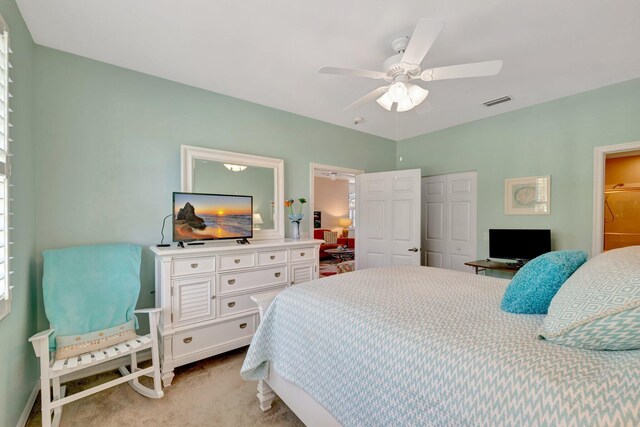 bedroom featuring visible vents, a closet, light carpet, baseboards, and a ceiling fan