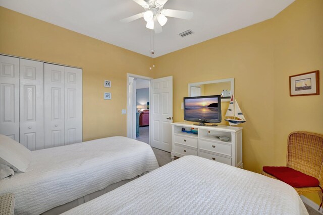 carpeted bedroom featuring ceiling fan, a closet, and visible vents