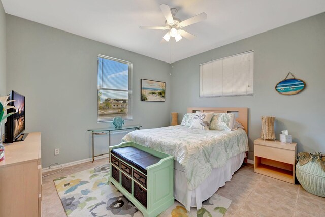 bedroom featuring light tile patterned flooring, baseboards, and a ceiling fan