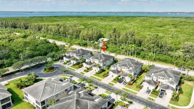 birds eye view of property featuring a water view, a residential view, and a wooded view