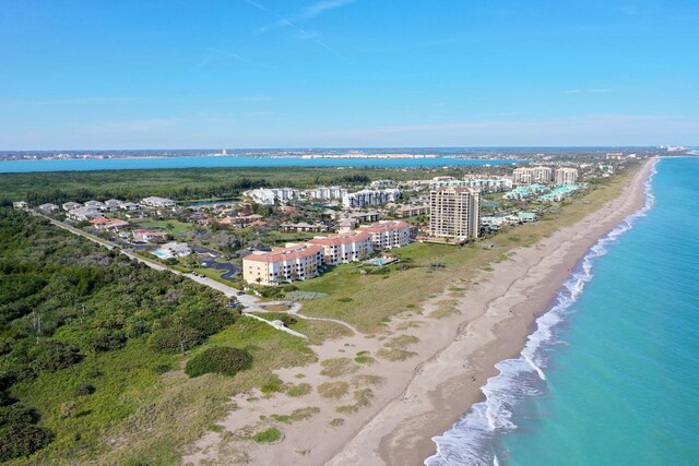 bird's eye view featuring a water view and a beach view