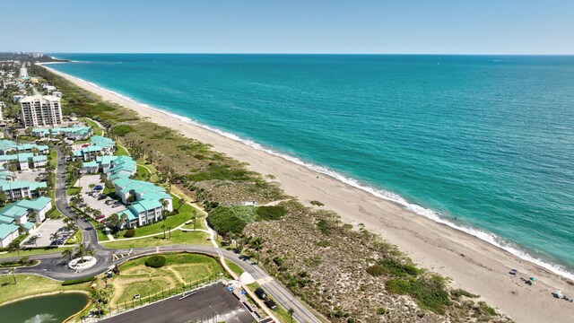 drone / aerial view with a beach view and a water view