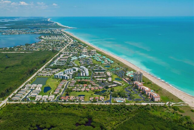 bird's eye view featuring a water view and a beach view