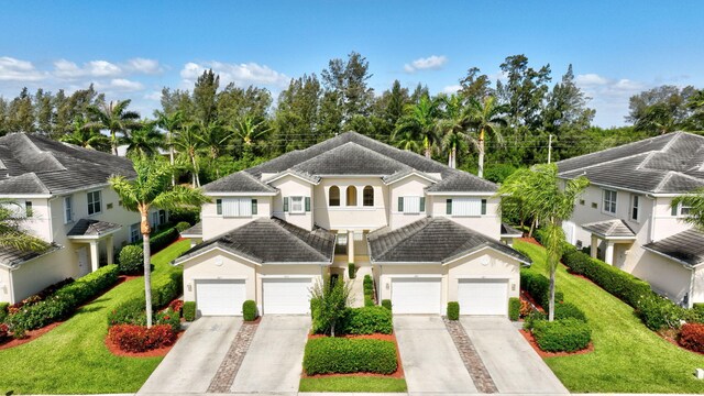 view of front of home featuring an attached garage, driveway, and stucco siding