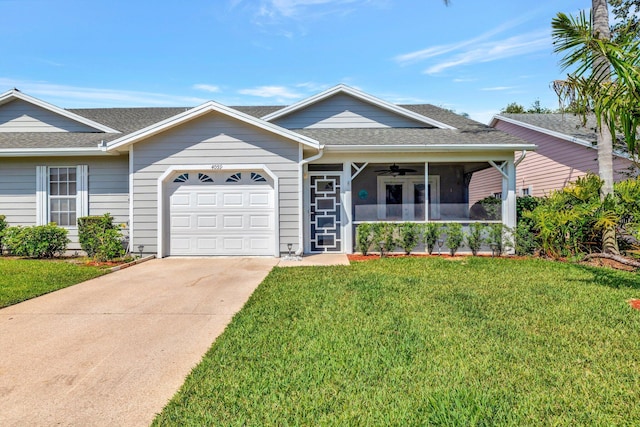 ranch-style home with a garage, covered porch, a front yard, roof with shingles, and a ceiling fan
