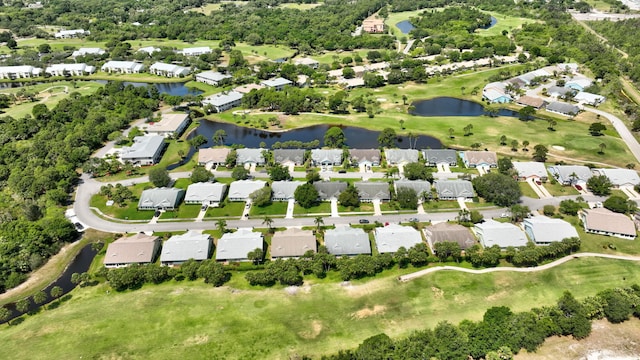 drone / aerial view with a water view, golf course view, and a residential view