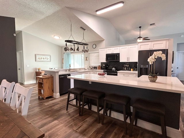 6446 Terra Rosa Cir, Boynton Beach, FL 33472 - kitchen featuring black appliances, vaulted ceiling, light countertops, a peninsula, and dark wood-style floors